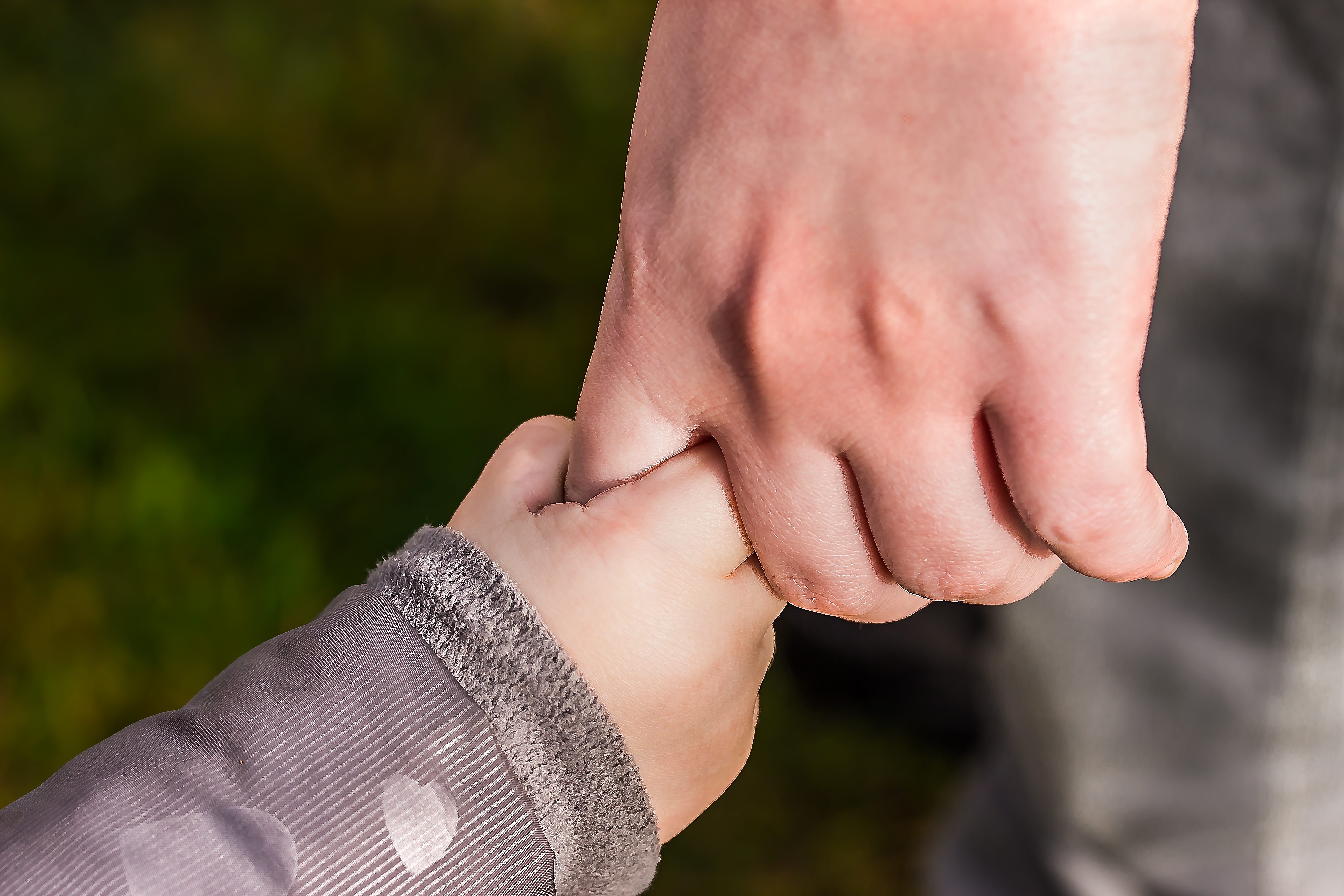 Mother holding hand with child after overcoming opiate addiction
